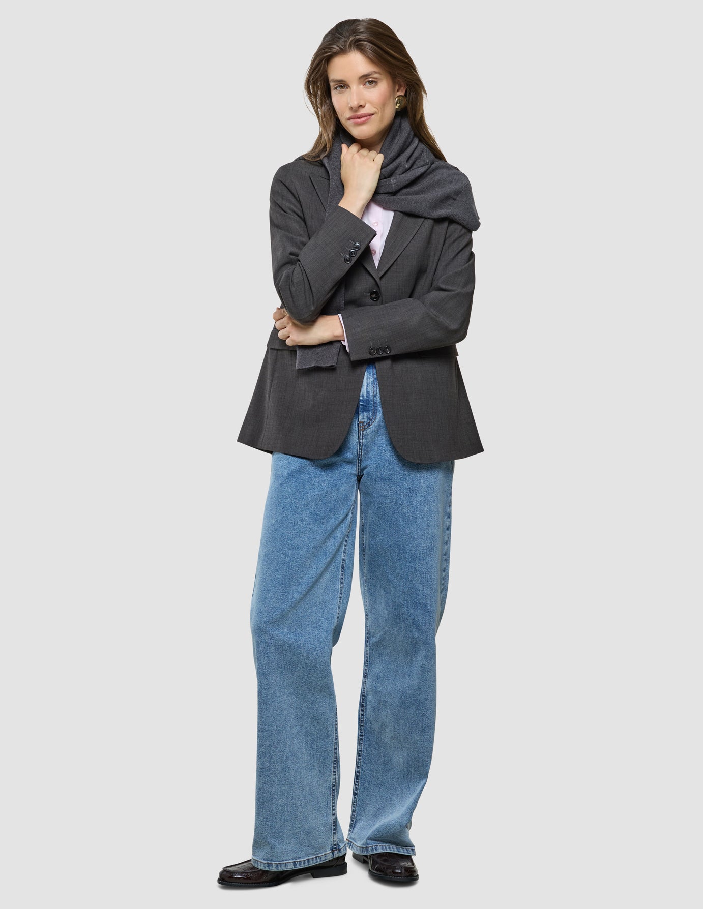 Nara Blazer i Cool Brown, helfigur af kvinde iført mørkebrun oversized blazer og blå jeans.